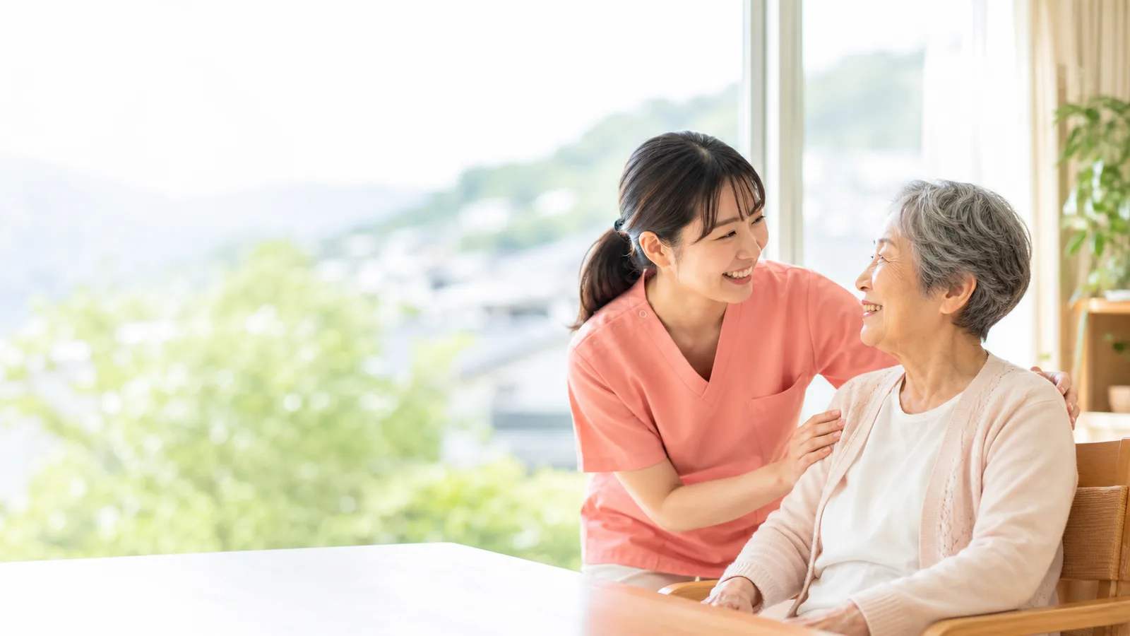 笑顔で話す介護スタッフと高齢女性